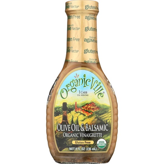 photo of vegan balsamic dressing light brown in glass jar and screw on cap packaging with a blue and green paper label