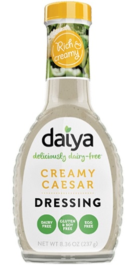 photo of vegan creamy caesar salad dressing packaged in glass bottle with screw on cap and white paper label